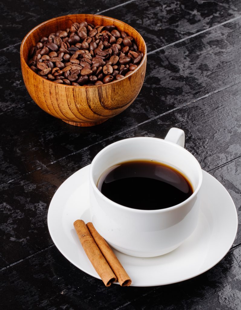 side view cup coffee with cinnamon sticks wooden bowl with coffee beans